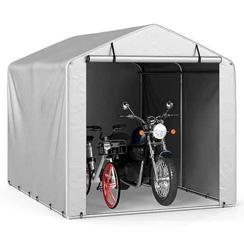 Abri vélos souple gris clair à porte enroulable, installé sur du gravier dans un jardin