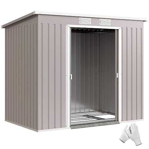 Abri de jardin métallique gris clair à double porte, installé dans un jardin ordonné